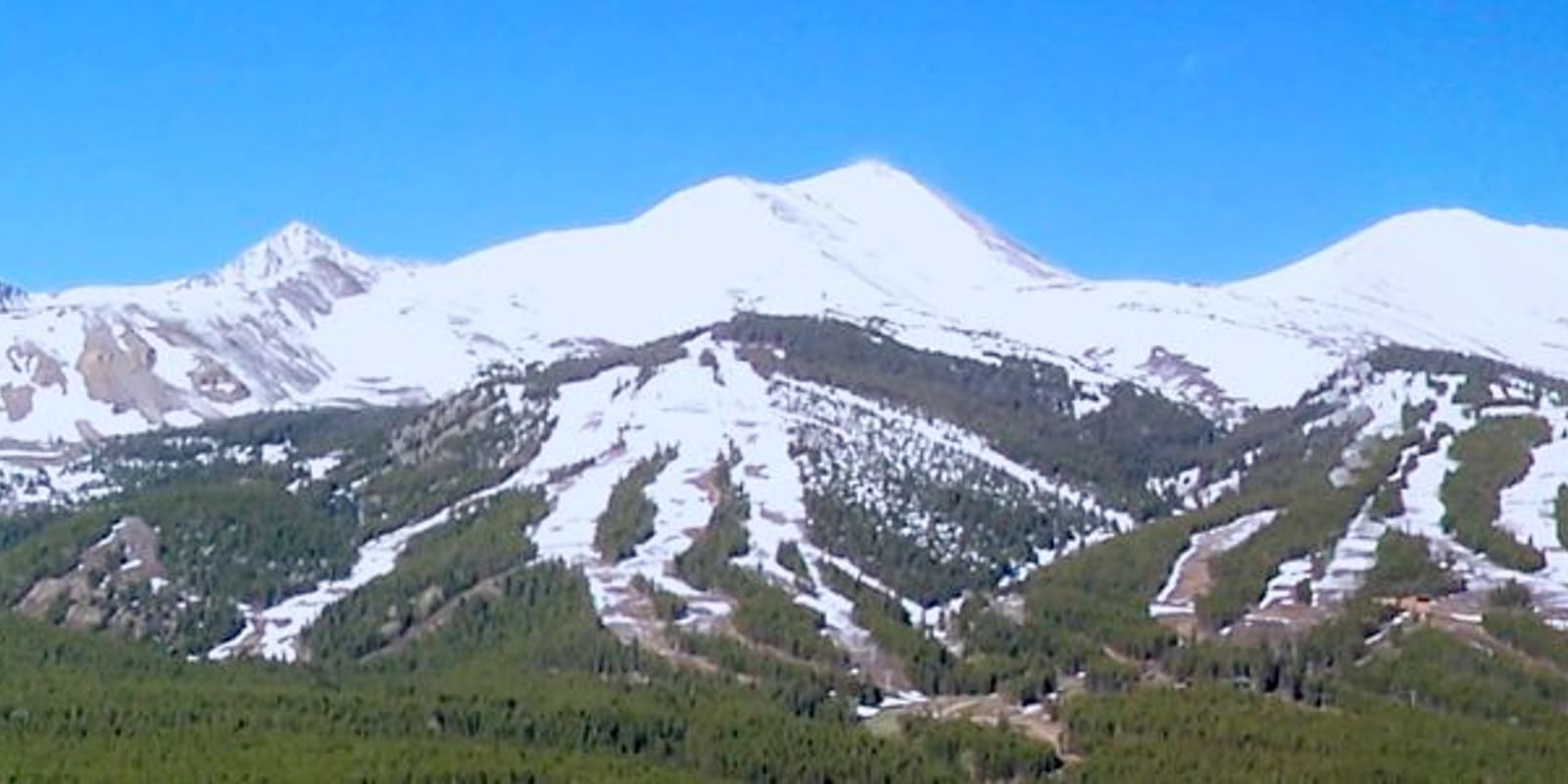 Snowy ski runs cut through the forest on the Breckenridge peaks